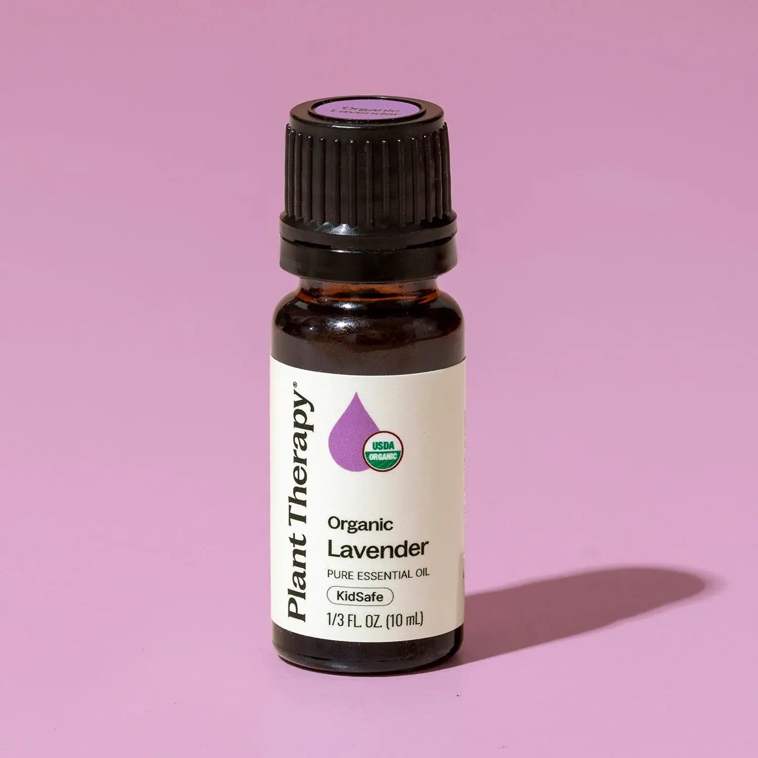 Bottle of Plant Therapy Organic Lavender essential oil on a pink background