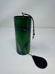 Green cylindrical container with a black paddle attached on a white background - JOY - Journey Of You - Spiritual, Holistic, Empowering