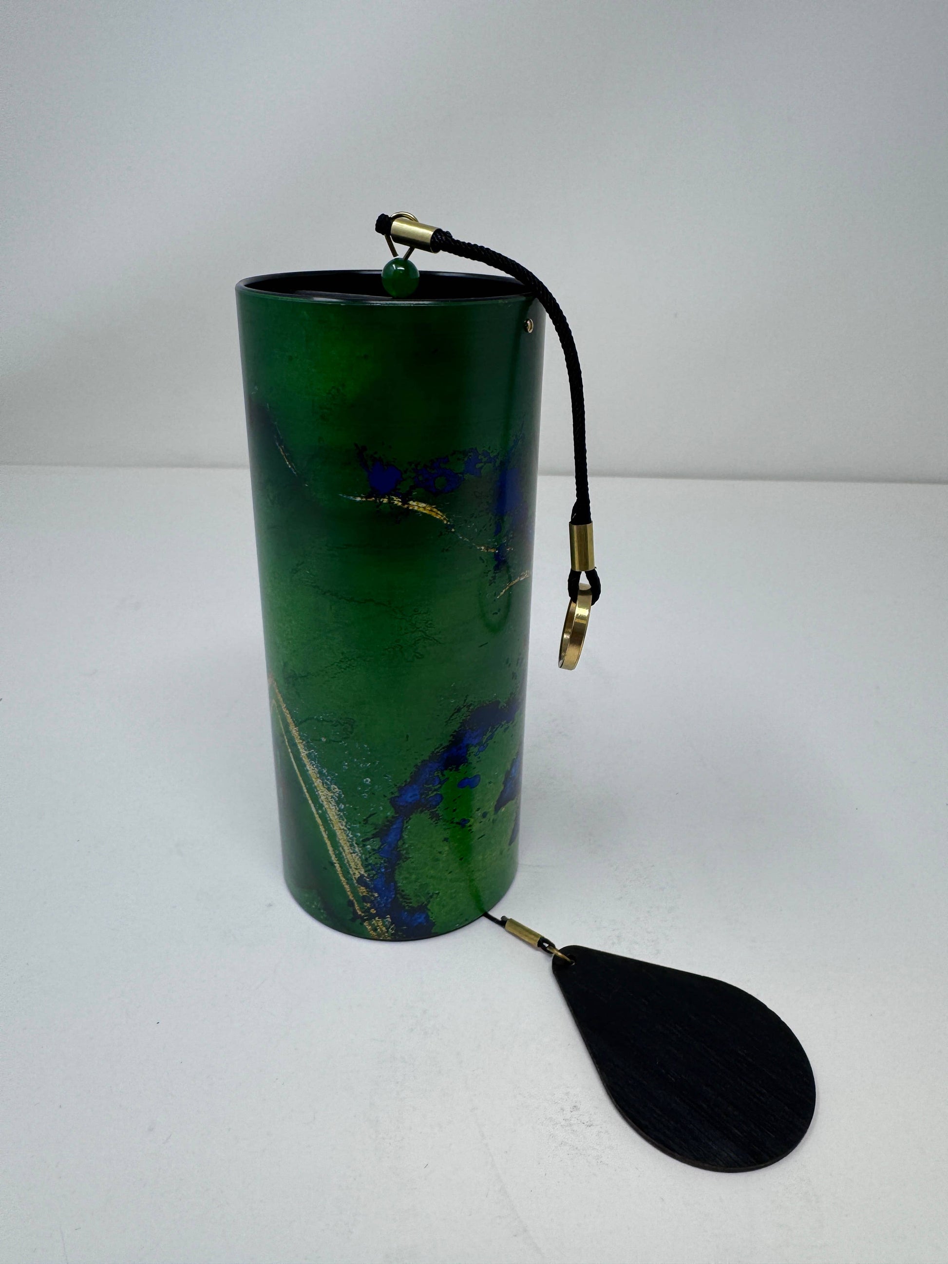 Green cylindrical container with a black paddle attached on a white background - JOY - Journey Of You - Spiritual, Holistic, Empowering