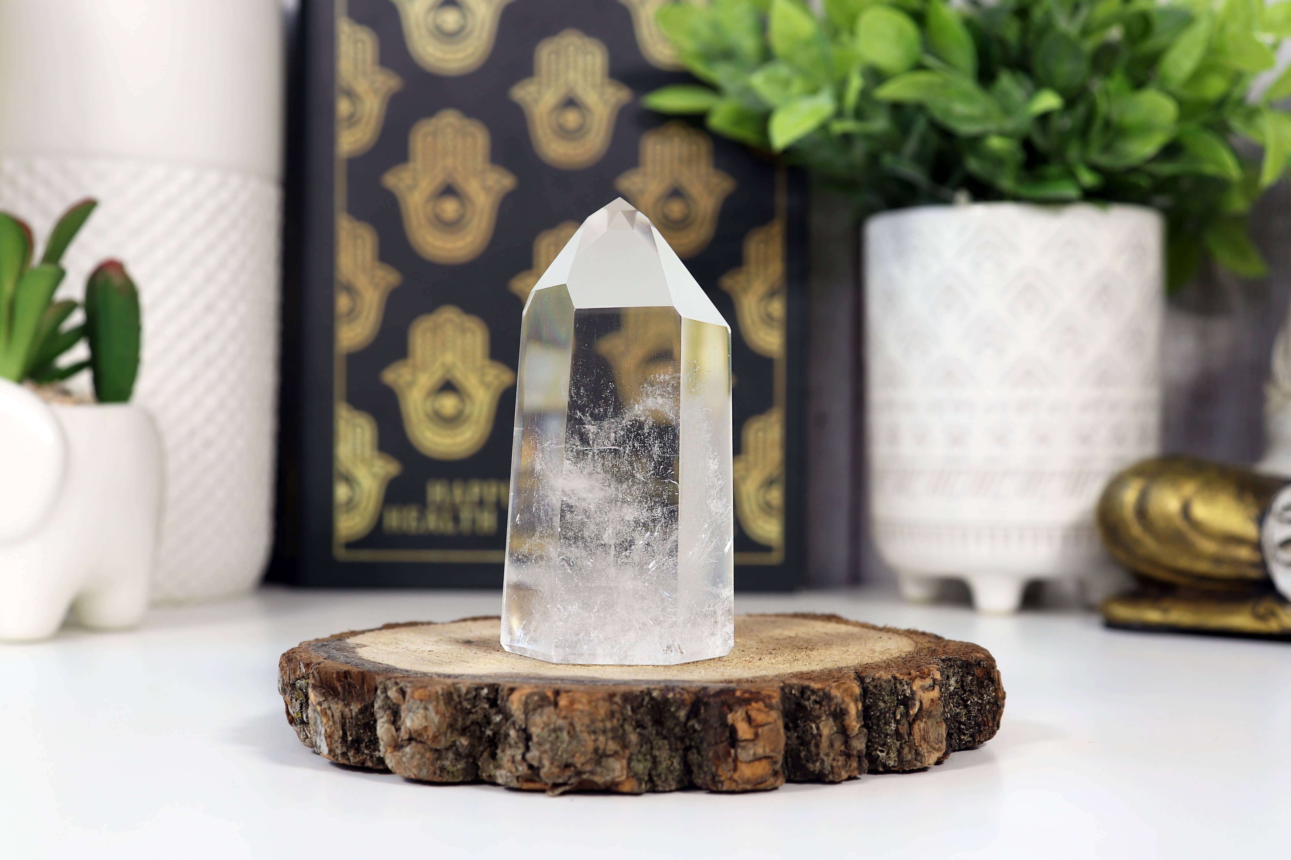 Clear crystal on a wooden stand with decorative items in the background