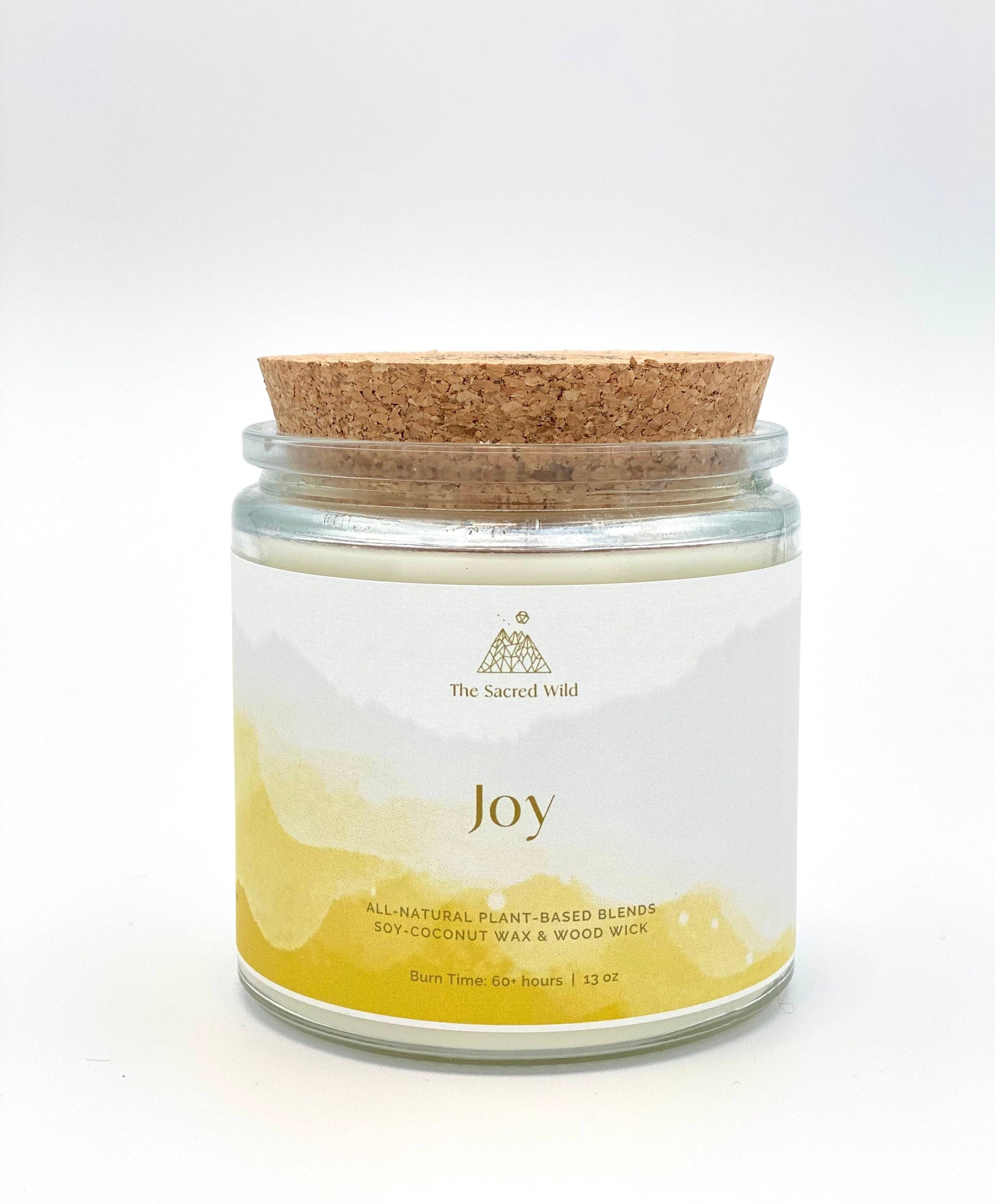 Candle jar labeled 'Joy' with a cork lid on a white background