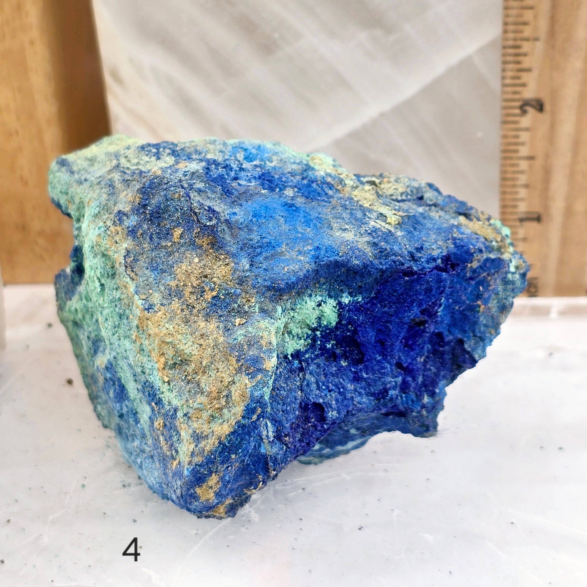 Blue mineral rock on a white surface with a wooden background