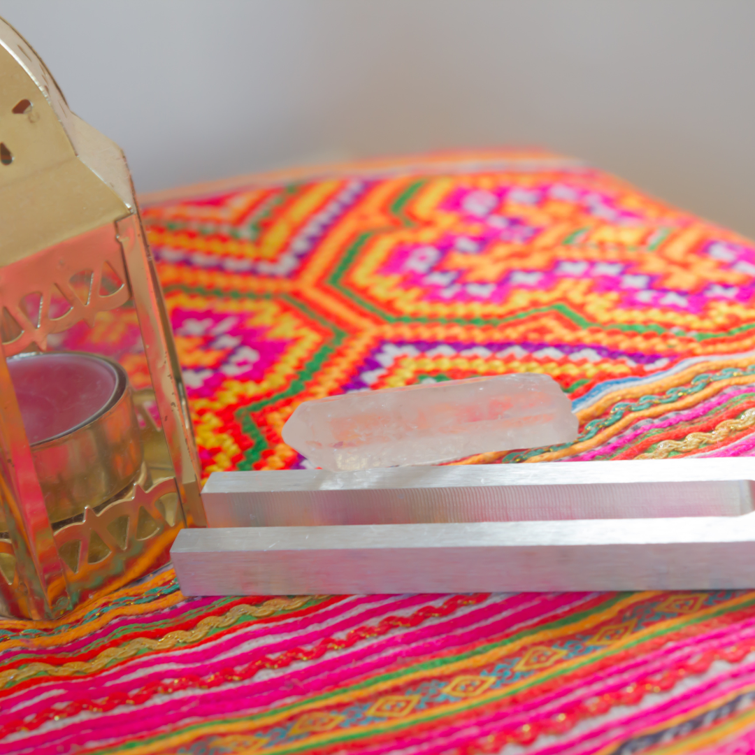 222 Hz Unweighted Tuning Fork: Decorative setup with a gold lantern, crystal, and colorful fabric on a white surface