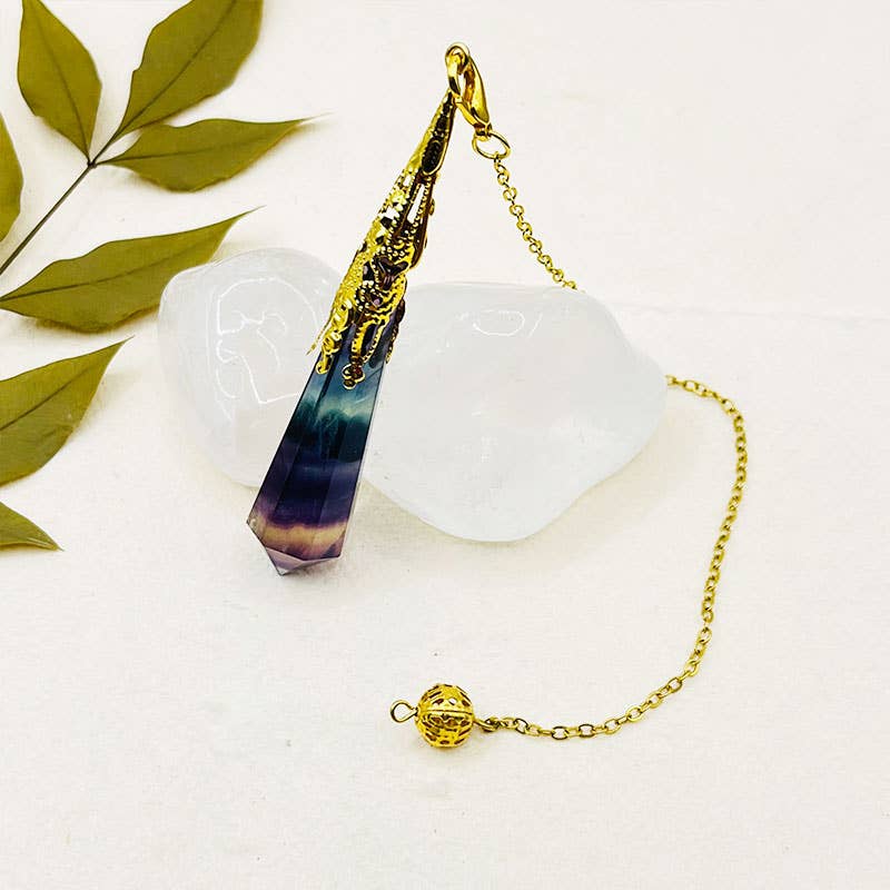 Decorative pendant with gold chain on a white background with green leaves