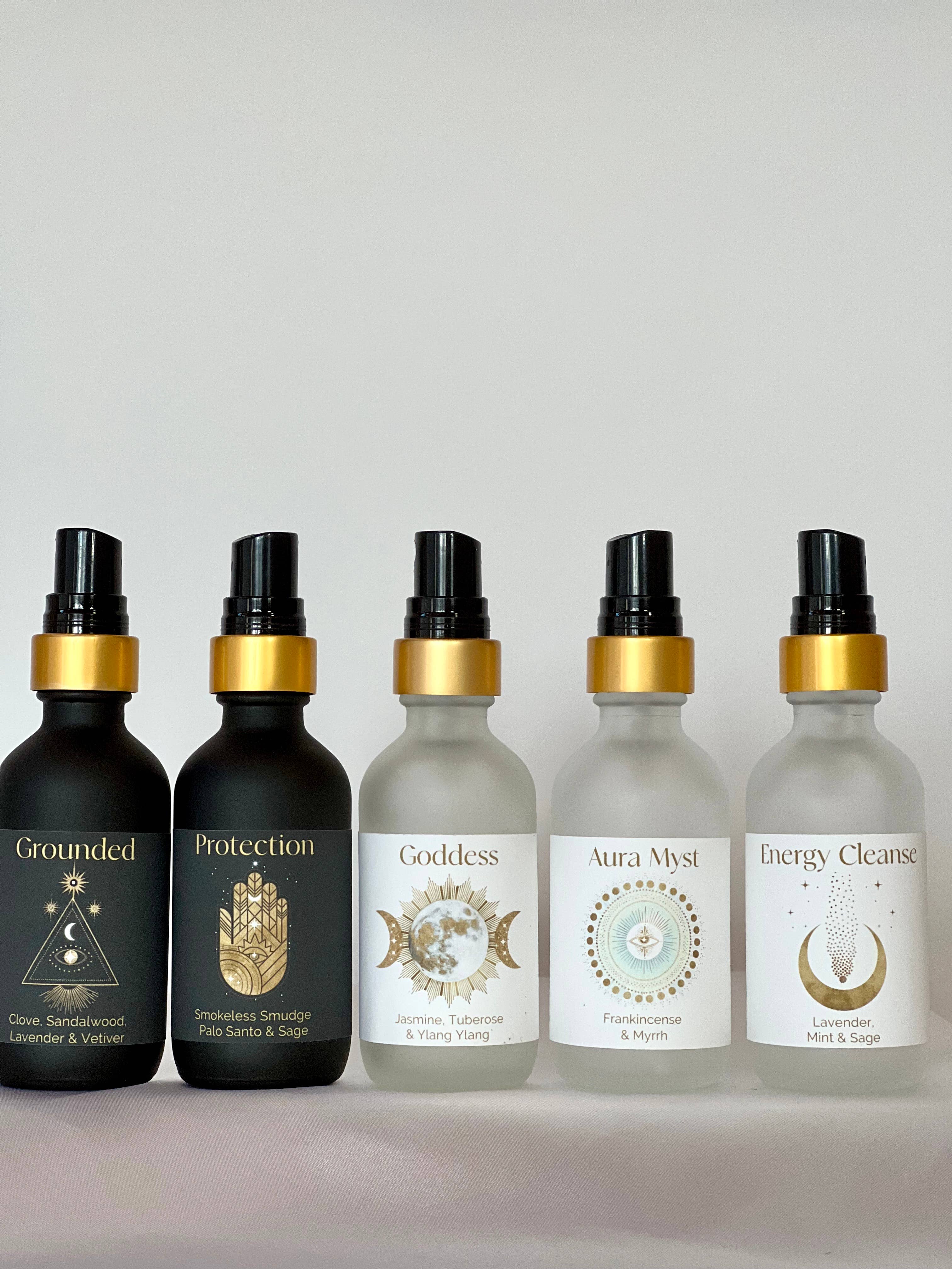 Five black bottles with gold caps on a gray background