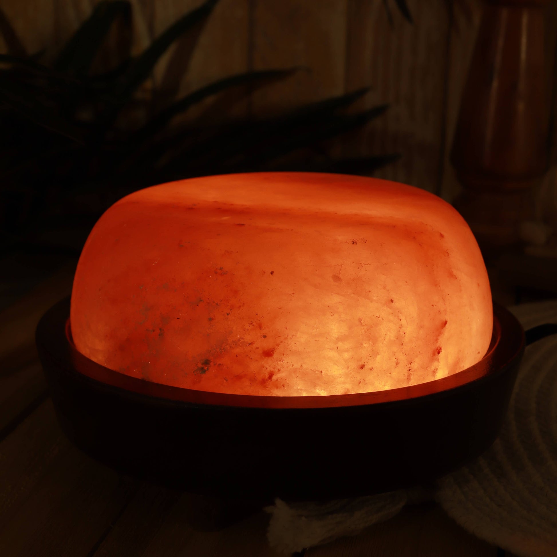 Himalayan salt lamp emitting a warm glow in a dimly lit room.