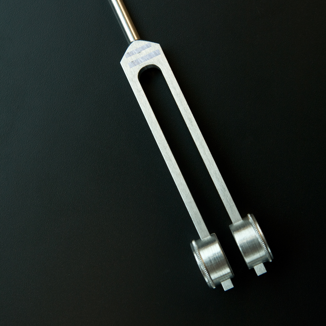 Metal tuning fork on a black background - JOY - Journey Of You - Spiritual, Holistic, Empowering