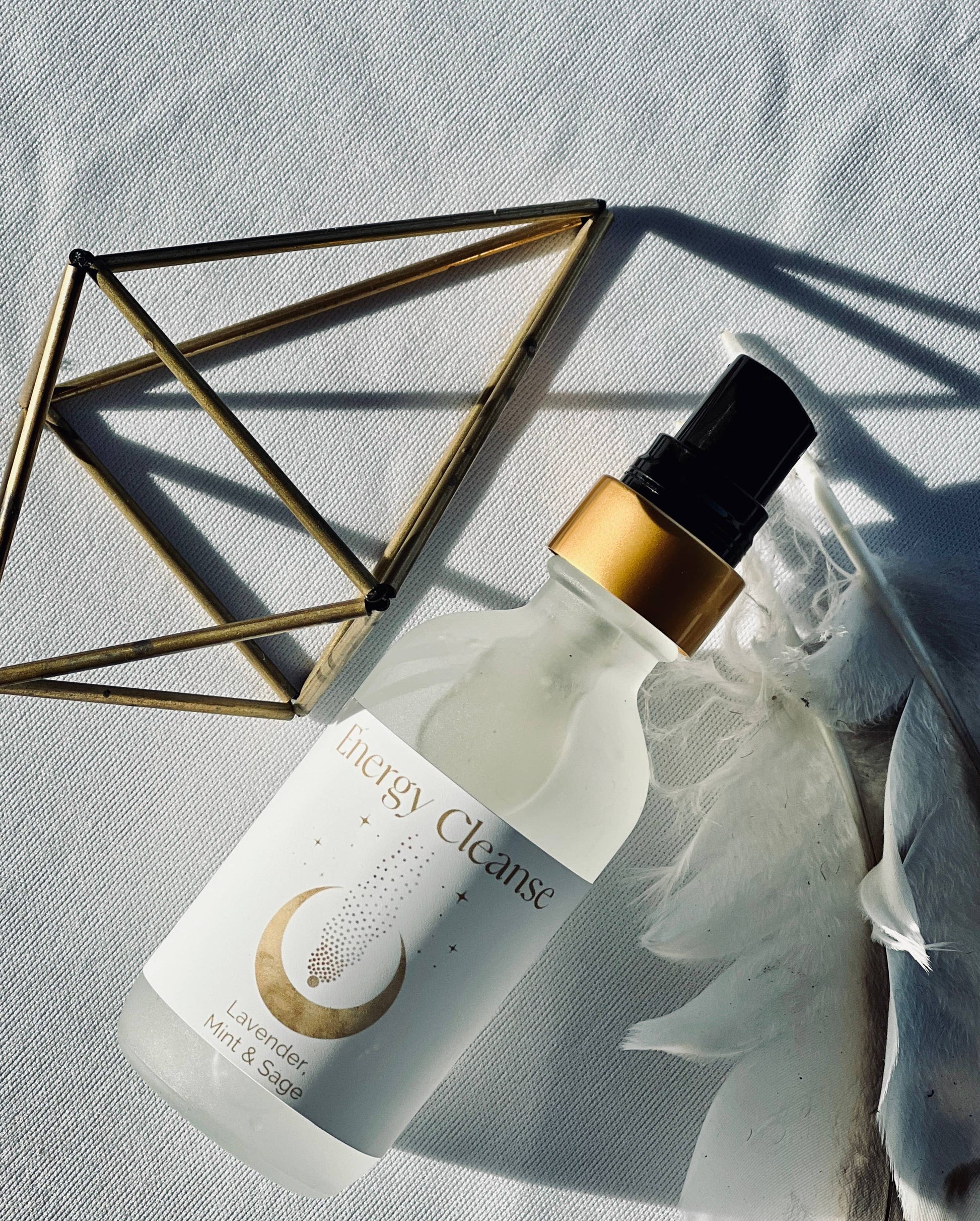 Skincare bottle labeled 'Energy Cleanse' on a textured surface with geometric decor.