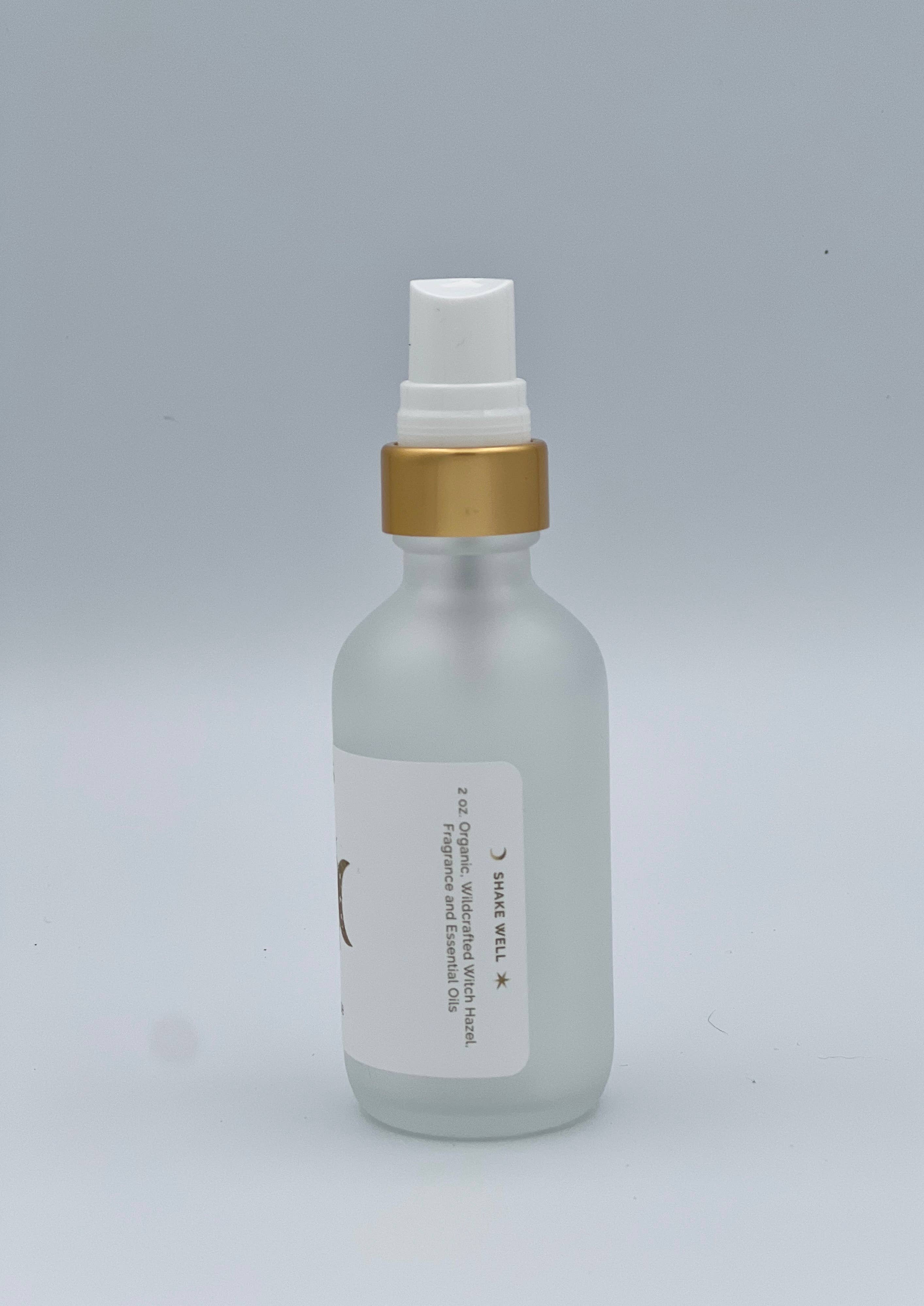 Clear bottle with gold cap and white label on a gray background