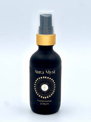 Aura Myst Frankincense & Myrrh bottle with gold cap on a light gray background