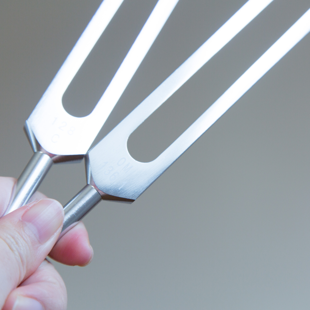 Metallic fork held by a hand against a gray background