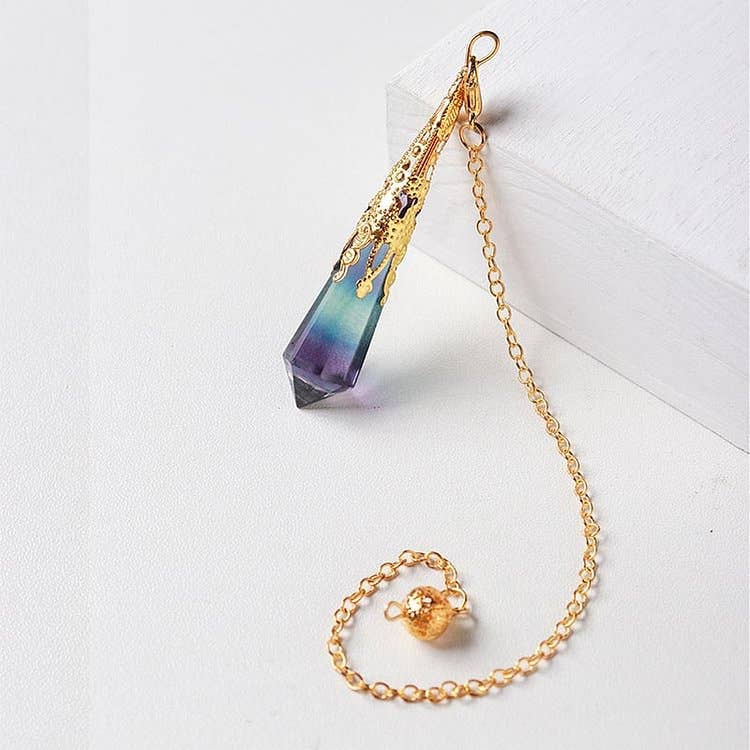 Gold chain with a teardrop-shaped purple and blue pendant on a white background