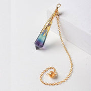 Gold chain with a teardrop-shaped purple and blue pendant on a white background