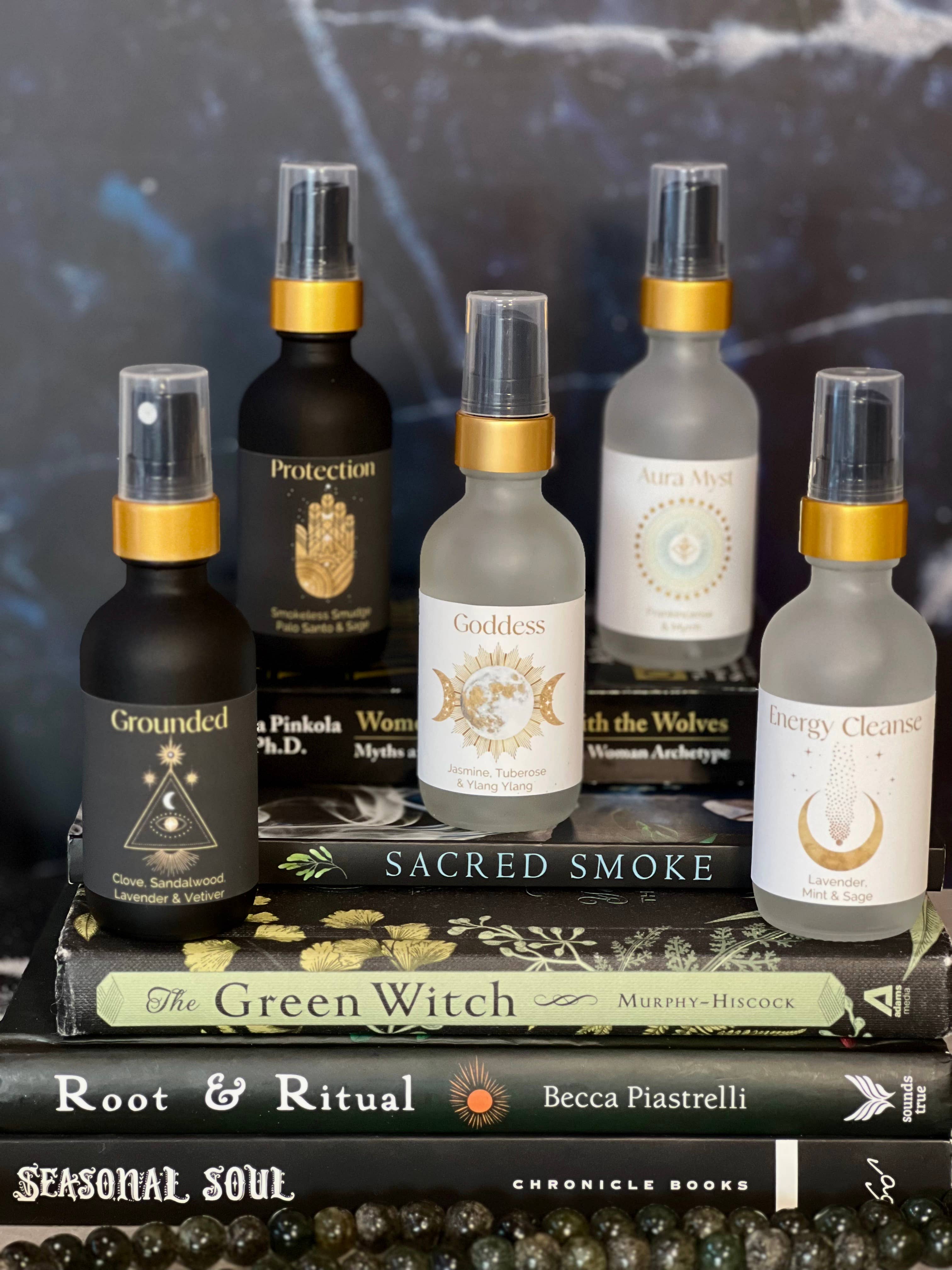 Collection of spiritual products including bottles and a book titled 'The Green Witch' on a dark background.