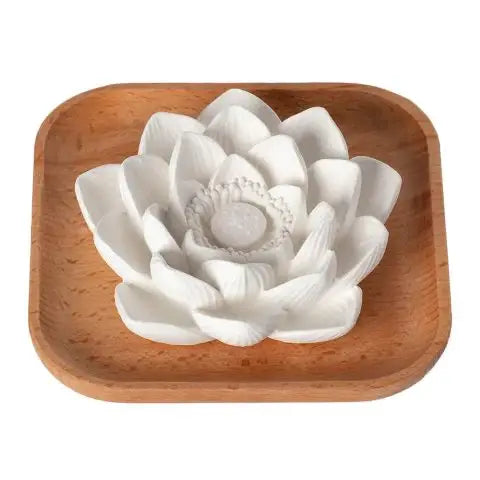 White ceramic lotus flower on a wooden tray