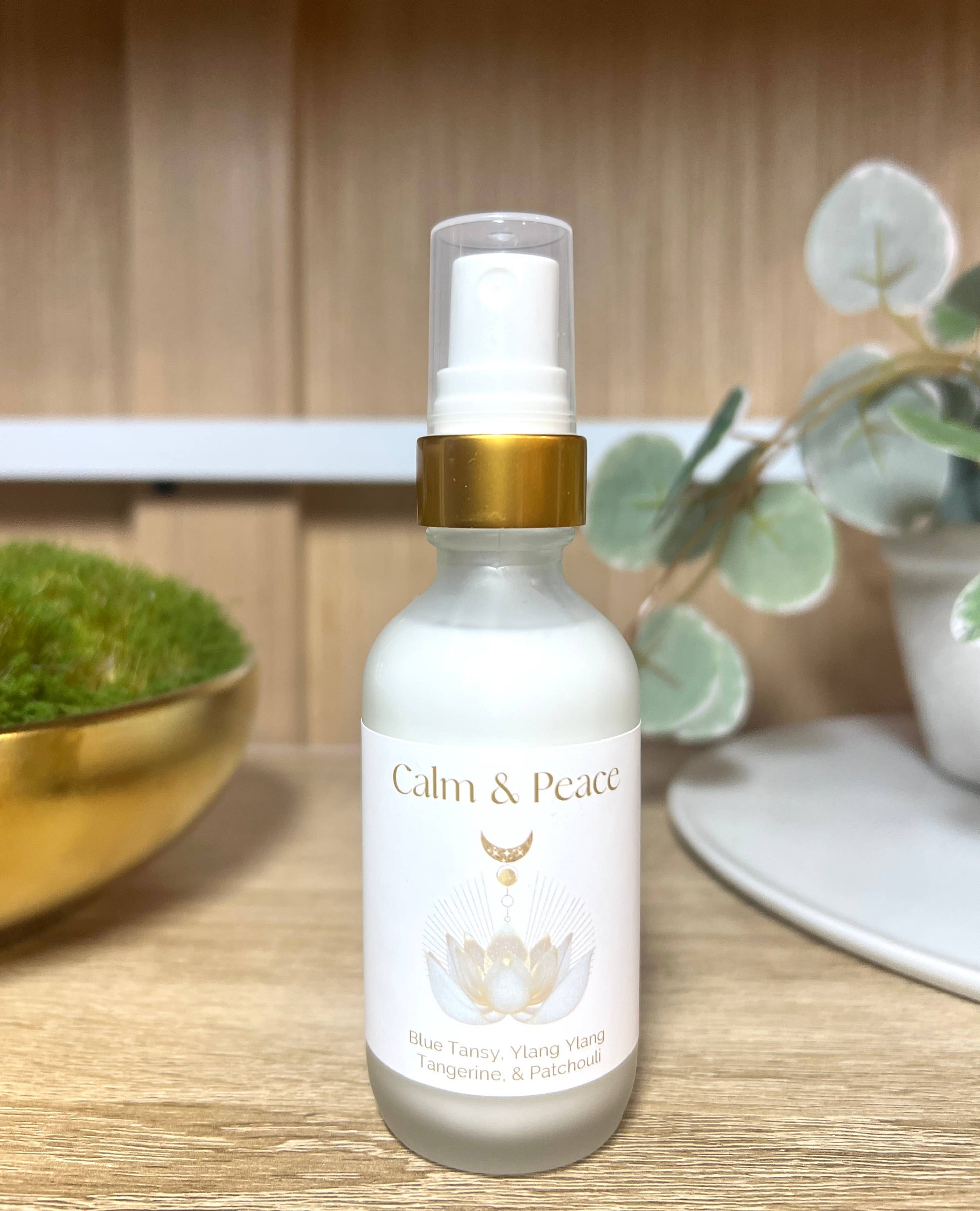 White bottle labeled 'Calm & Peace' on a wooden surface with decorative elements.