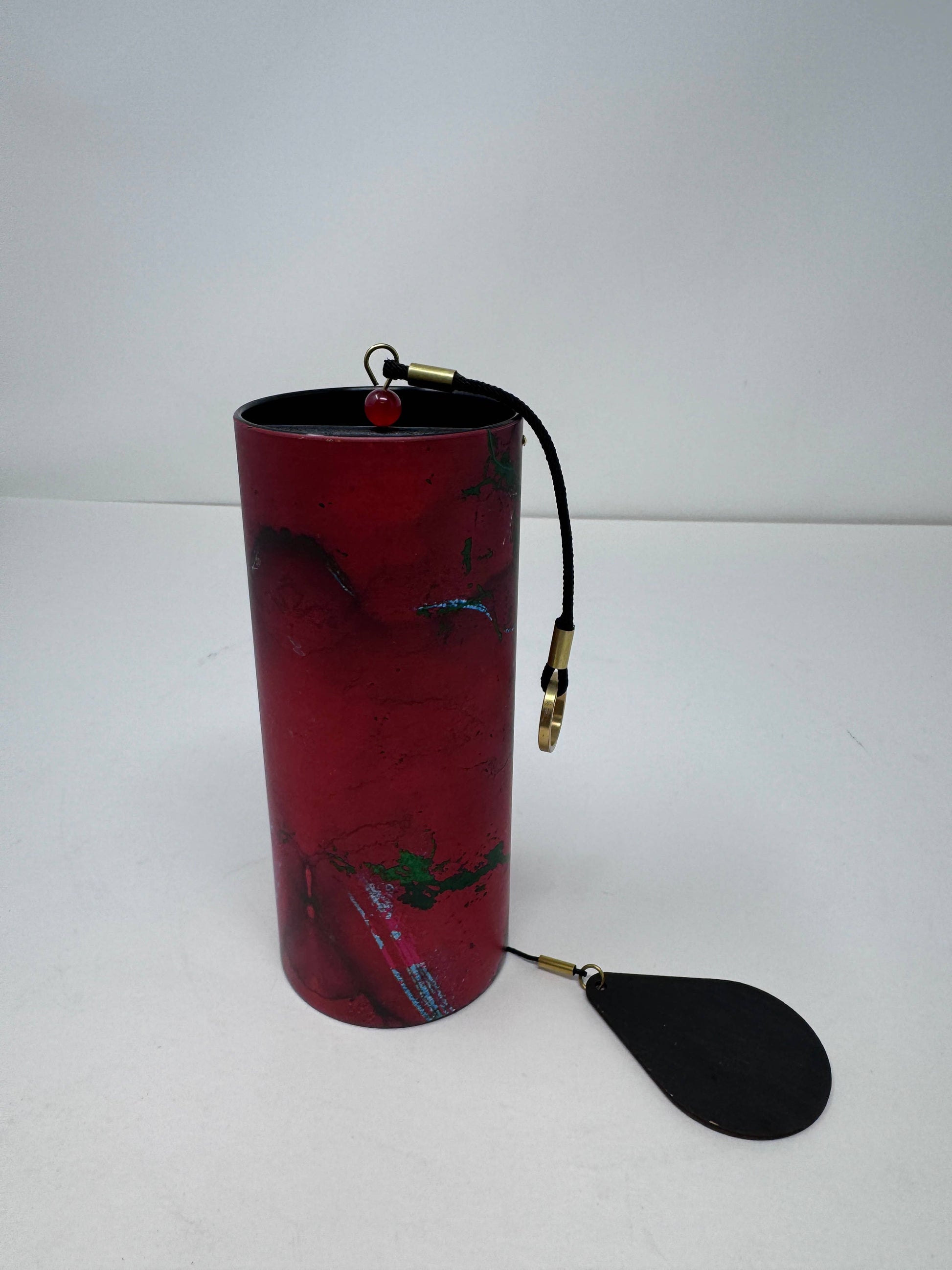 Red cylindrical container with a black paddle attached on a white background - JOY - Journey Of You - Spiritual, Holistic, Empowering