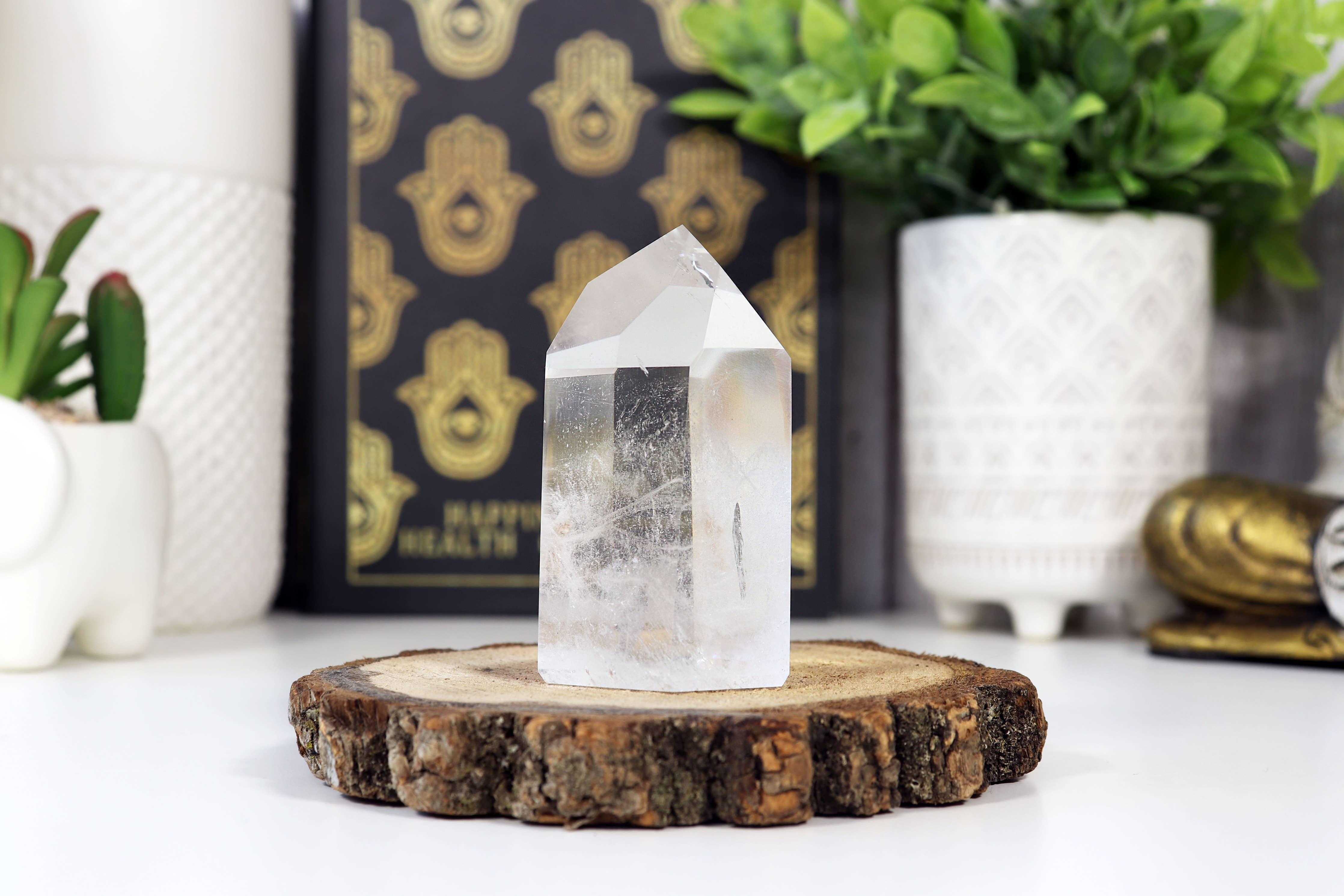 Clear crystal on a wooden stand with decorative items in the background