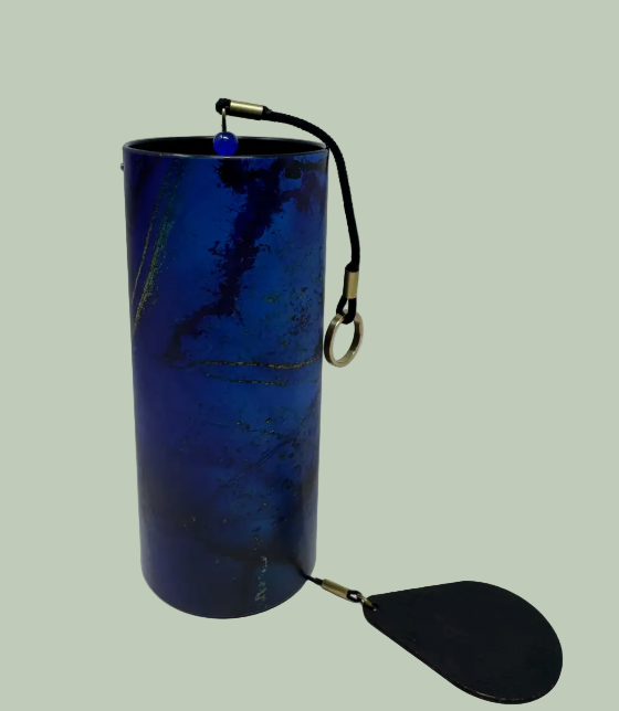 Wind Chimes  Blue cylindrical object with a black handle and flap on a light gray background
