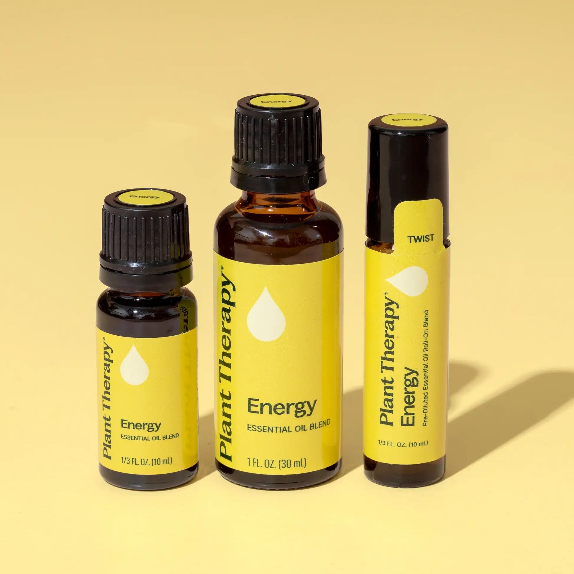 Three bottles of Plant Therapy Energy essential oil blend on a yellow background - JOY - Journey Of You - Spiritual, Holistic, Empowering
