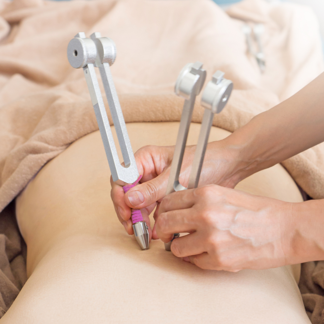 Person using a handheld electronic device on their leg, likely for medical or therapeutic purposes - JOY - Journey Of You - Spiritual, Holistic, Empowering