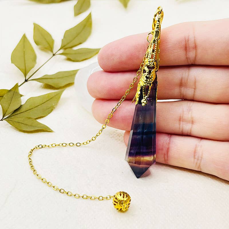 Crystal pendant with gold chain held in hand on a light background