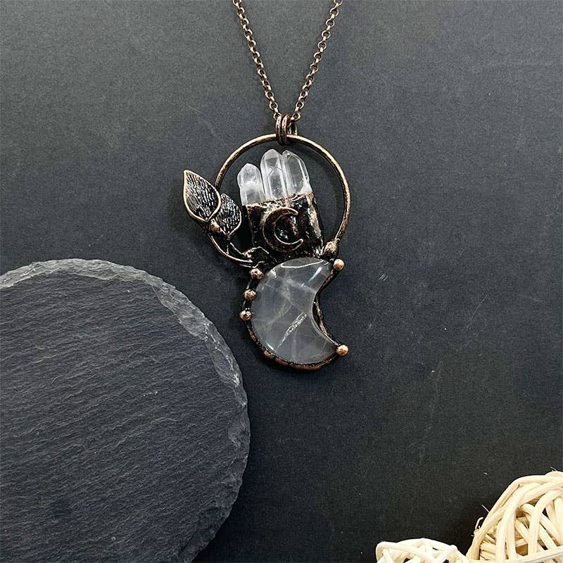 Necklace with a pendant featuring a camera and moon design on a dark background