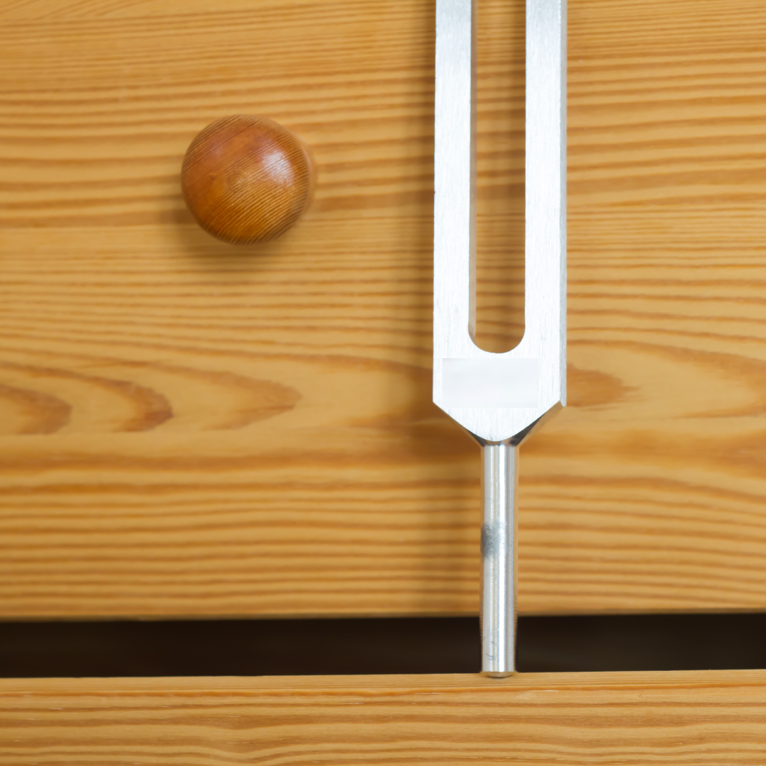 Metal tuning fork on a wooden surface