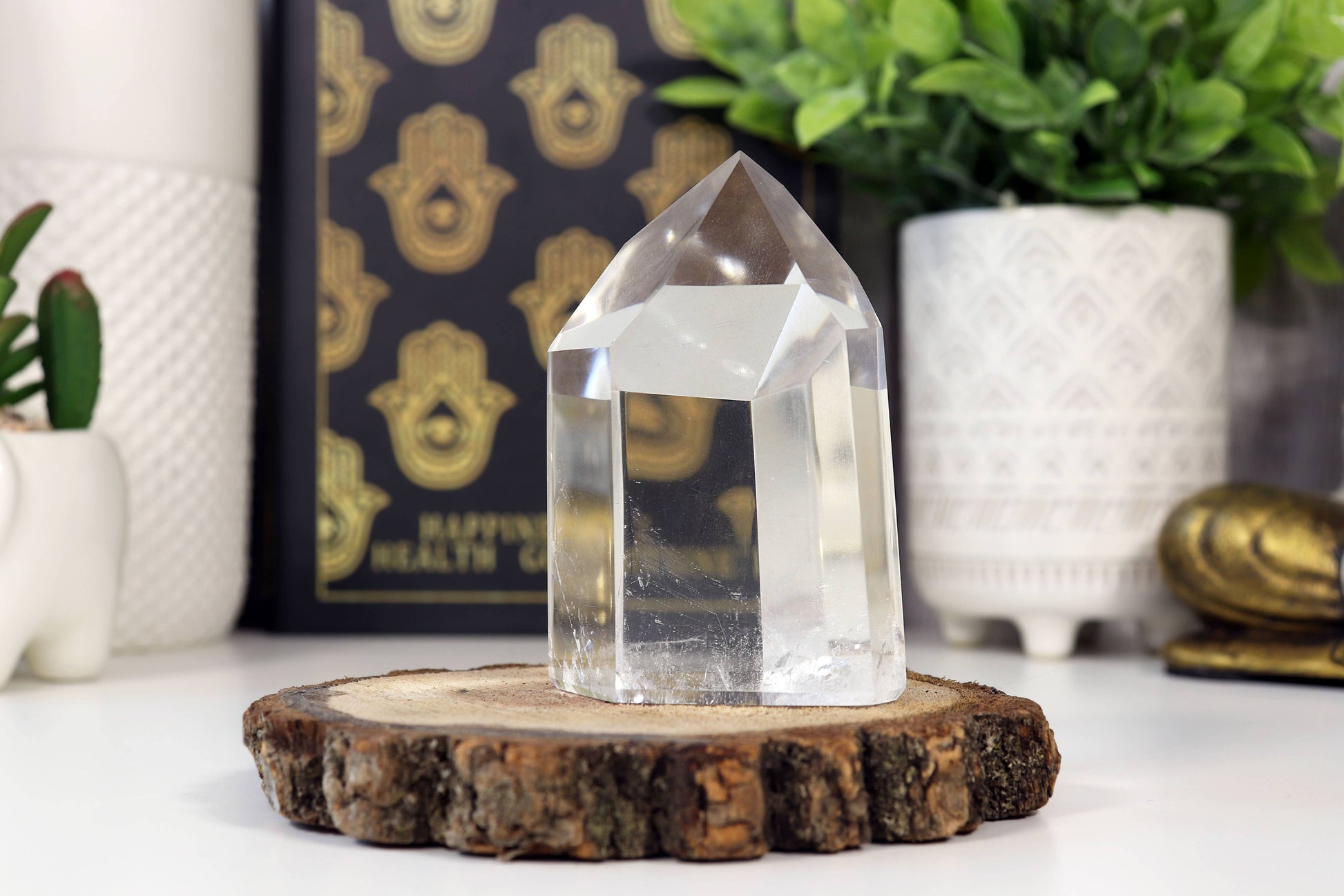 Clear crystal on a wooden stand with decorative items in the background