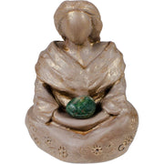 Small figurine of a person holding a green stone on a white background