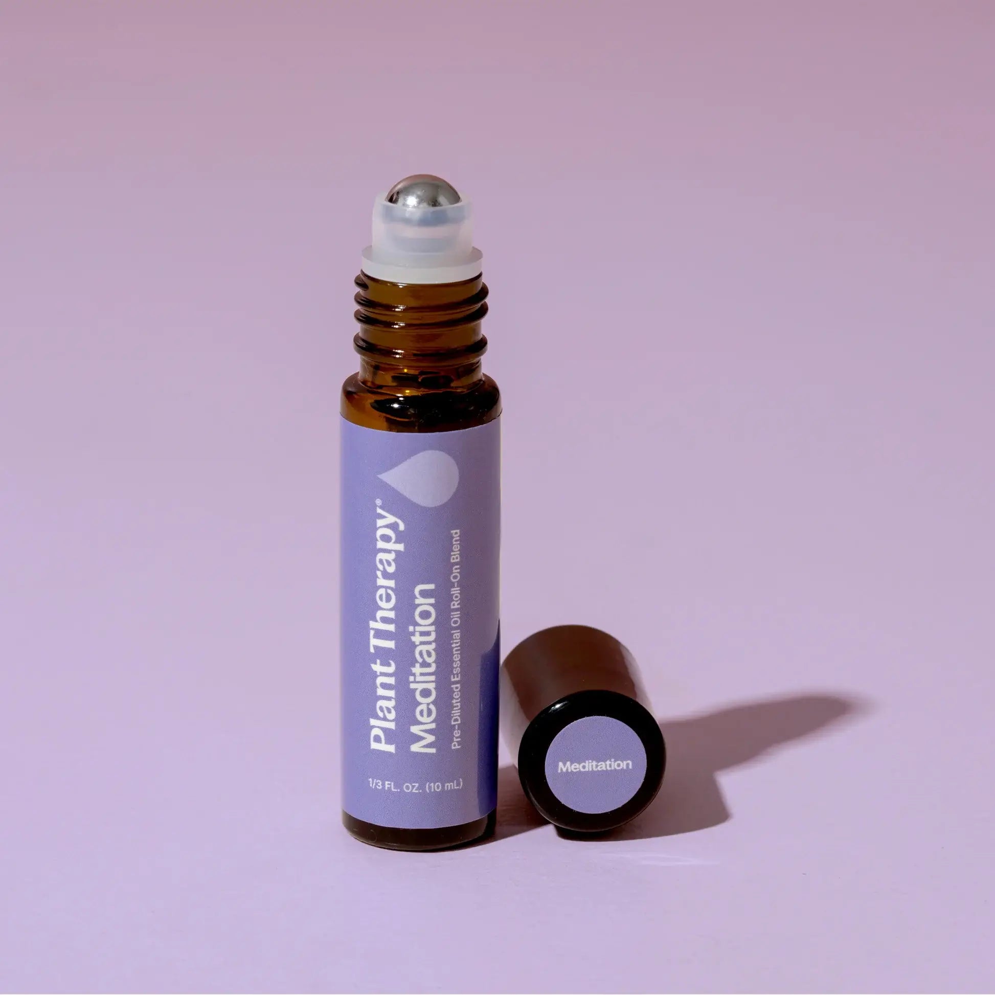 Roll-on bottle of Plant Therapy Meditation essential oil on a pink background - JOY - Journey Of You - Spiritual, Holistic, Empowering