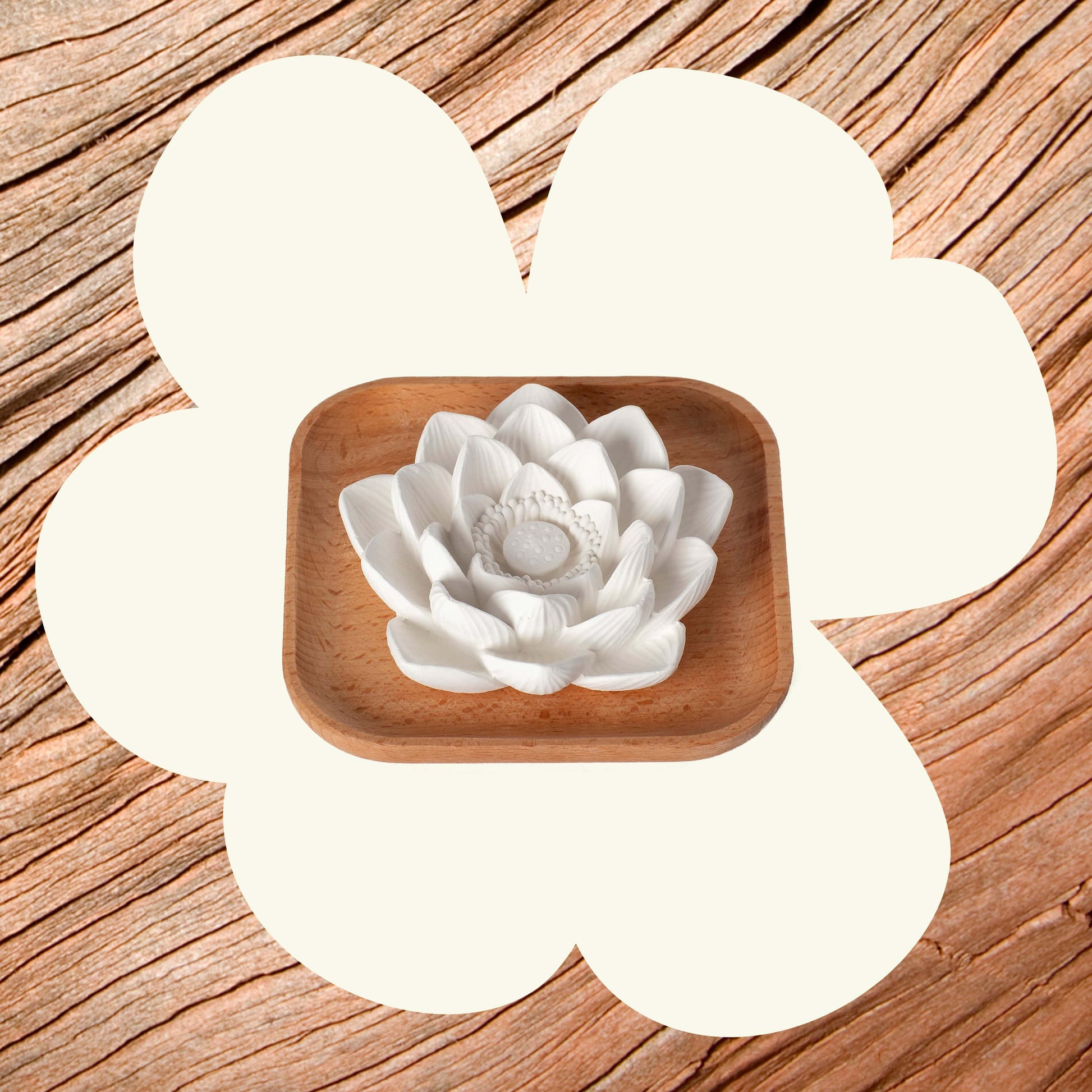 White ceramic flower in a wooden bowl on a wooden surface