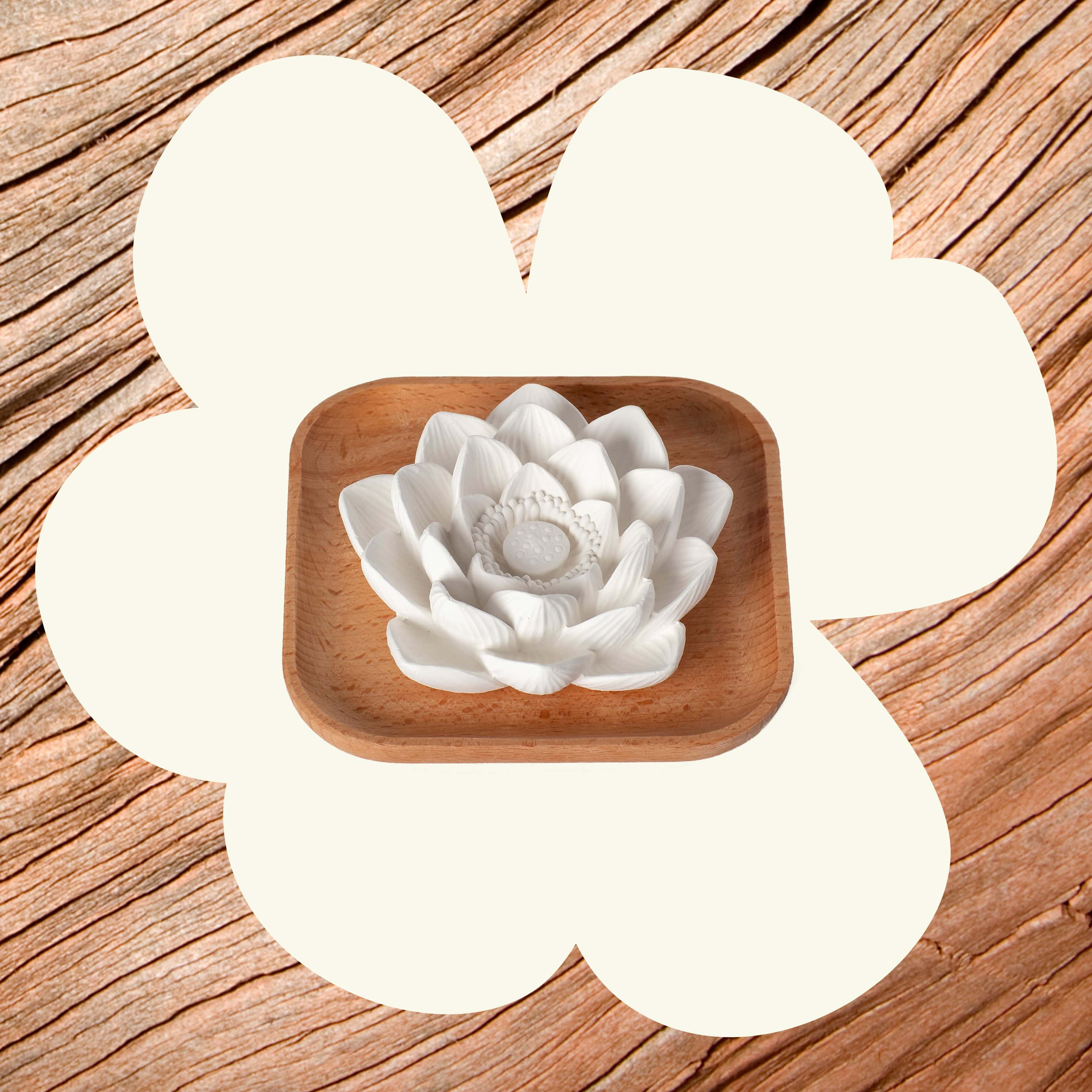 White ceramic flower in a wooden bowl on a wooden surface